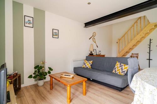 a living room with a blue couch and a table at Gîte à la campagne Les Ch'tis Normands 