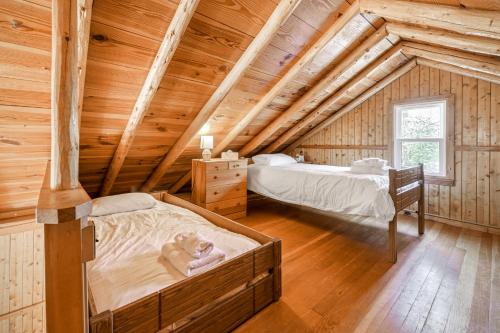 a bedroom with two beds in a log cabin at Omena Point Paradise Waterfront Sunrise in Suttons Bay
