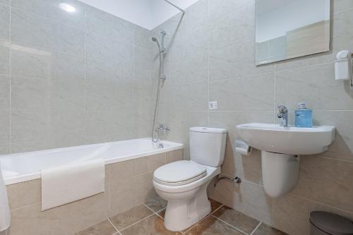 a bathroom with a toilet and a sink and a bath tub at Stylish One-Bedroom Sea Retreat in Paralimni