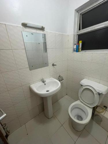 a white bathroom with a toilet and a sink at The Costal Sunny Daze,076 8976 732 in Mombasa