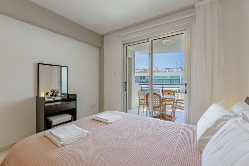 a bedroom with a bed with a view of a balcony at Stylish One-Bedroom Sea Retreat in Paralimni