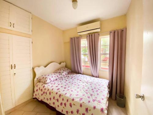 um pequeno quarto com uma cama e uma janela em Fayalobie Centrally Located 2 BR Guesthouse em Willemstad