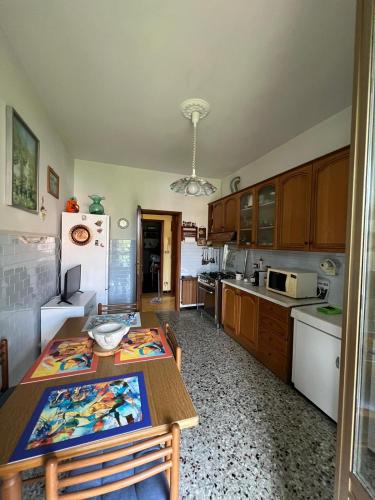 a kitchen with a table and a refrigerator at La Primula Vicinanza 5 Terre in Riccò del Golfo di Spezia