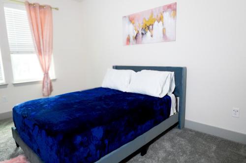 una camera con un letto blu e un dipinto sul muro di Lions' Lair Luxury Loft at Galleria - King Bed - Pool a Houston