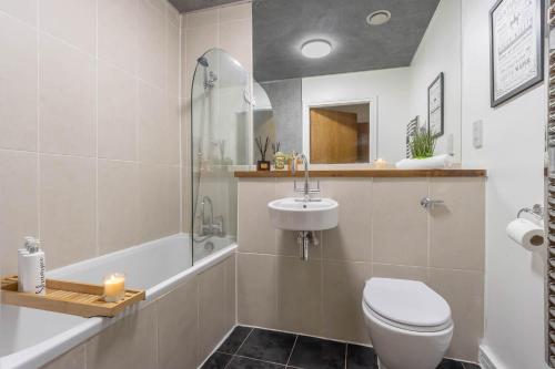 Un baño con inodoro, lavabo y bañera. en Stylish 2 bedroom City Centre Apartment sleeps 6 with Free Convenient Bullring , Grand Central Parking, en Birmingham