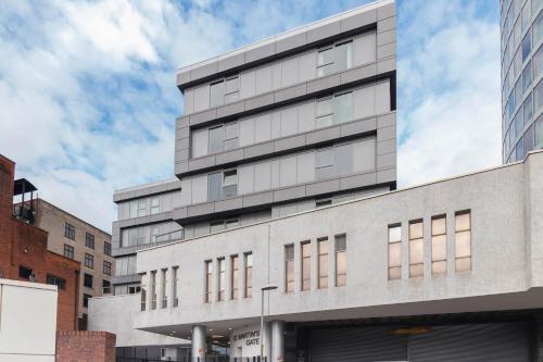 a tall gray building with windows on a city street at Stylish 2 bedroom City Centre Apartment sleeps 6 with Free Convenient Bullring , Grand Central Parking in Birmingham