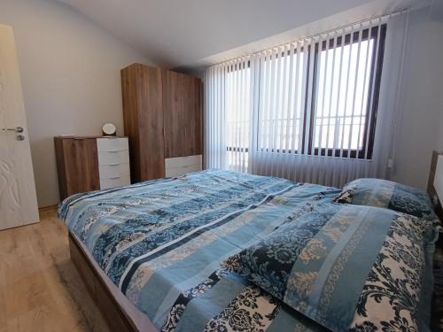 a bedroom with a bed and a large window at Витски in Ruse