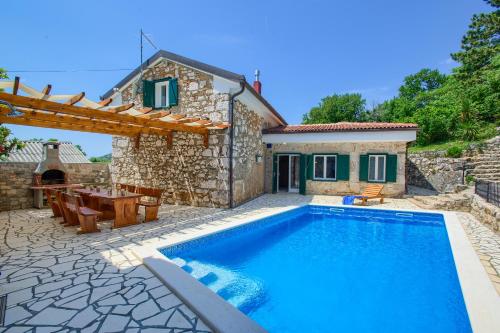 a villa with a swimming pool in front of a house at Villa Kirica in Bribir