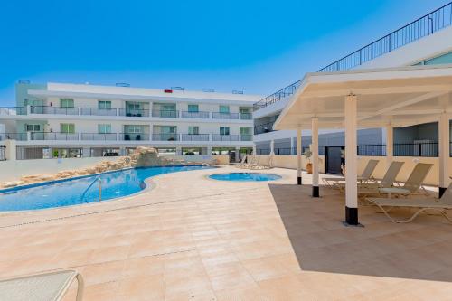 a large building with a swimming pool and a pavilion at Stylish One-Bedroom Sea Retreat in Paralimni