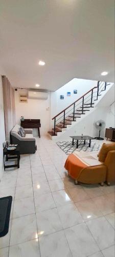 Una sala de estar con un sofá y una escalera. en La Maison transient house, en Calapan