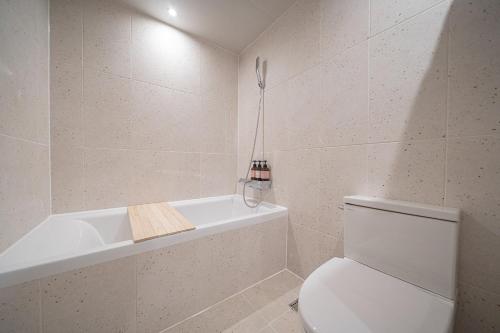 a bathroom with a toilet and a bath tub at Aank Hotel Daejeon Yuseong 2nd in Daejeon