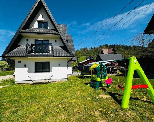 a house with a yard with a playground at Tatrzański Domek & SPA in Poronin