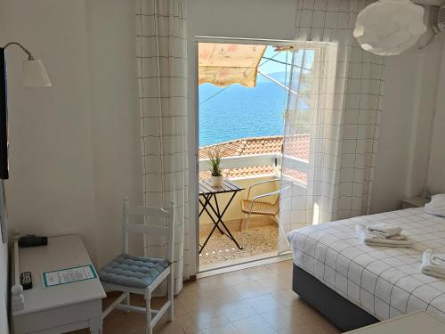 a bedroom with a bed and a view of the ocean at Hotel Rania in Loutra Edipsou