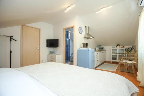 a bedroom with a white bed and a blue refrigerator at Z&A Studio apartment with parking in Božava