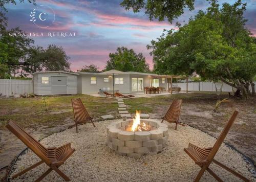 a fire pit in a yard with chairs and a house at Casa Isla Retreat - near Anna Maria Island in Bradenton