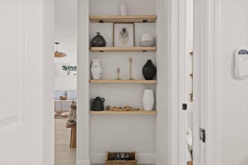 a hallway with shelves with vases and vases at Casa Isla Retreat - near Anna Maria Island in Bradenton