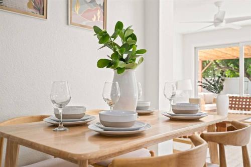 a dining room table with a vase with a plant at Casa Isla Retreat - near Anna Maria Island in Bradenton