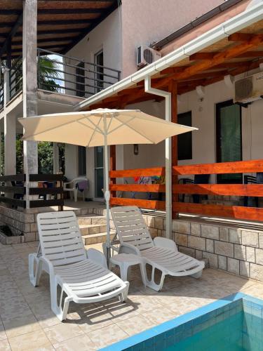 two lounge chairs and an umbrella next to a pool at GRAMISI apartments in Kruče