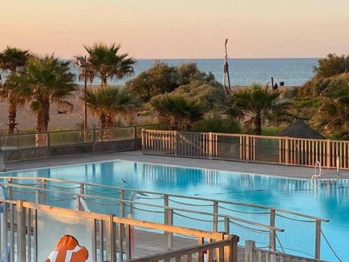 une piscine avec l'océan en arrière-plan dans l'établissement Mobil-home au Camping Bleu Marine, à Sérignan