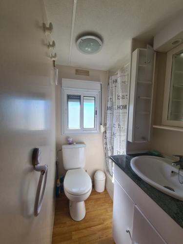 une salle de bain avec toilettes et lavabo dans l'établissement Mobil-home au Camping Bleu Marine, à Sérignan