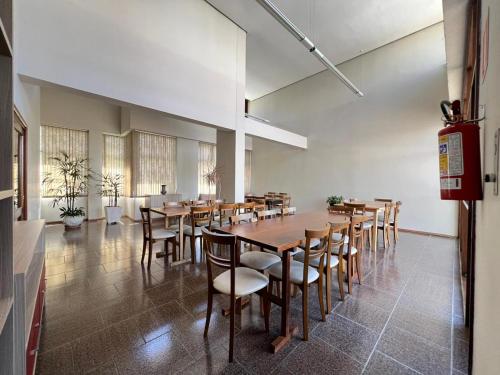 een grote eetkamer met houten tafels en stoelen bij Quarto em Apartamento Amplo e Confortável in Caxias do Sul