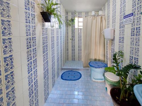 a bathroom with a blue and white tiled wall at Hostel Pajeú in Triunfo