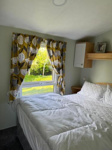 a bedroom with a white bed and a window at Golden palm in Chapel Saint Leonards