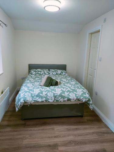 een slaapkamer met een bed met een blauw dekbed bij Bank street apartment in Ossett