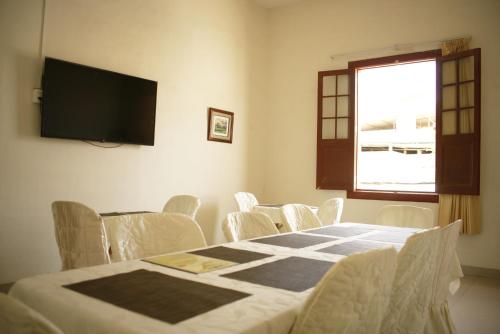 Habitación con mesa, sillas y TV. en Estancia Real en Piura