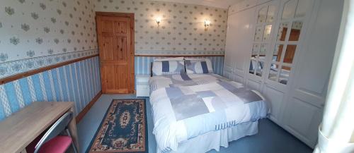 a small bedroom with a bed and a wooden door at Village Cottage in Dunkineely