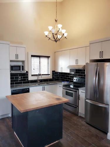 a kitchen with white cabinets and a stainless steel refrigerator at Calgary-Banff single house close LRT&UC&Free Parking in Calgary