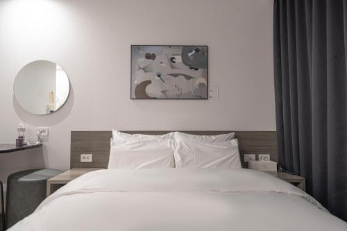 a bedroom with a white bed and a mirror at Aank Hotel Daejeon Yuseong 2nd in Daejeon