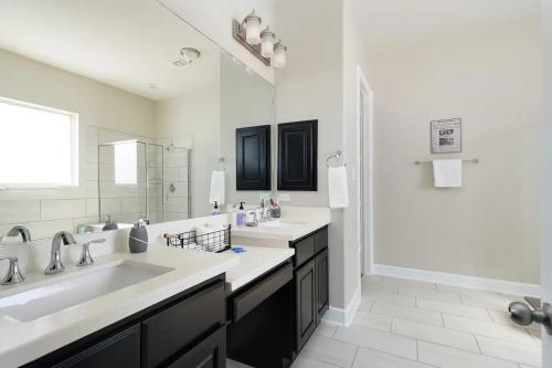 a bathroom with two sinks and a large mirror at Launch Pad- A Birdy Vacation Rental in Helotes