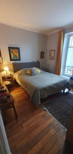 une chambre avec un grand lit et un parquet dans l'établissement L'élégance à proximité du centre aquatique des JO, à Levallois-Perret