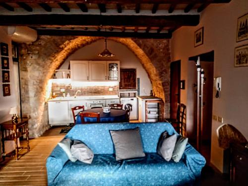 ein Wohnzimmer mit einer blauen Couch in einer Küche in der Unterkunft Studio dell'Arco - Assisi in Assisi