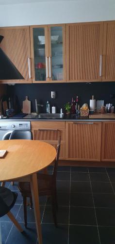 une cuisine avec une table en bois et une table et des chaises dans l'établissement L'élégance à proximité du centre aquatique des JO, à Levallois-Perret