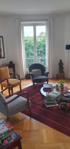 een woonkamer met een bank en een tafel bij L'élégance à proximité du centre aquatique des JO in Levallois-Perret