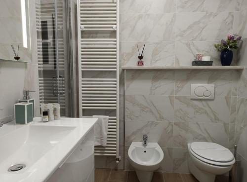 Baño blanco con aseo y lavamanos en Appartamenti Borghetto Panigale, en Bolonia