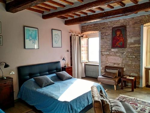 ein Schlafzimmer mit einem Bett und einer Ziegelwand in der Unterkunft Studio dell'Arco - Assisi in Assisi