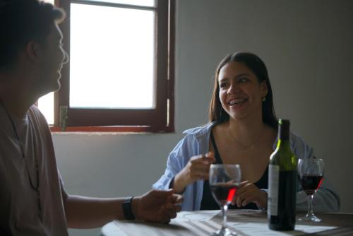 dos personas sentadas en una mesa con copas de vino en Estancia Real en Piura