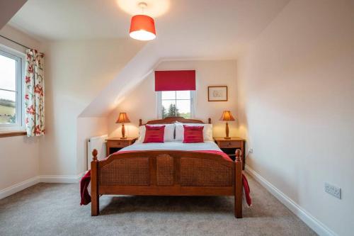een slaapkamer met een bed met rode kussens en een raam bij Alnwood in Chesters