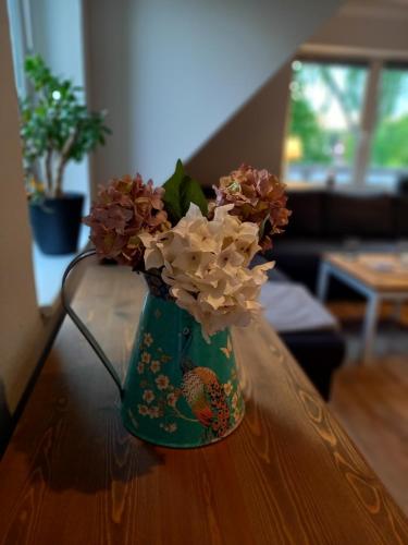 a green vase filled with flowers on a table at Luhe Idyll in Luhdorf