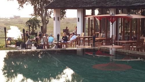 a group of people sitting around a swimming pool at Villa Inle Boutique Resort in Nyaung Shwe