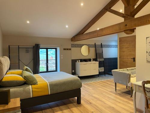 a bedroom with a large bed and a bathroom at Au Petit Bonheur chez Bambina in Leynes