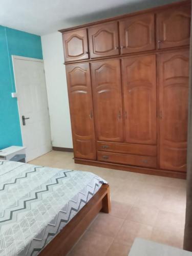 a bedroom with a bed and wooden cabinets at Villa Belle in Port Louis