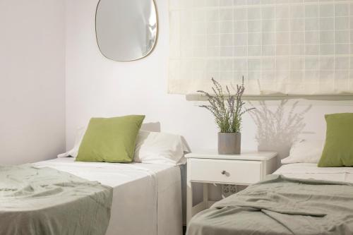 two beds in a room with green pillows and a mirror at Cozy Apartment 50 meters beach in Calafell