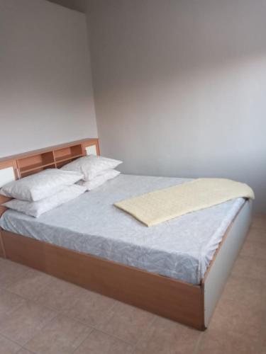 a bed with a wooden headboard and pillows on it at Villa Belle in Port Louis