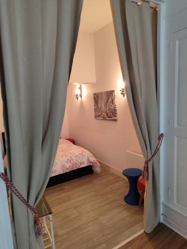 - une chambre avec un lit et un rideau dans l'établissement Chez Paulette, à Vendôme