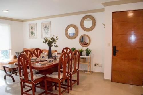 a dining room with a table and chairs and mirrors at 3BR Sn Rafael CDMX metro, mercado, Reforma, Zócalo in Mexico City
