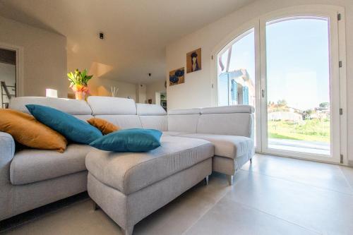 een woonkamer met een bank, een stoel en een raam bij Casa Grotti: Charm & Comfort vicino al Mare in Capezzano Pianore,
